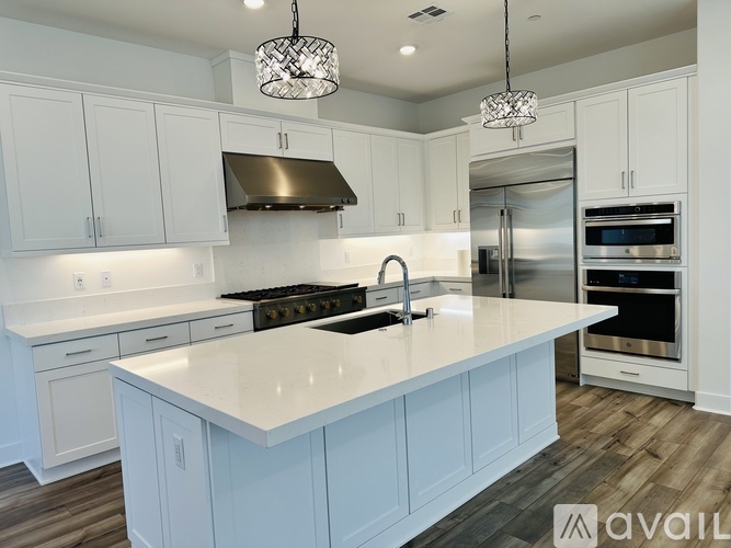 A modern kitchen with white cabinets and a large island.