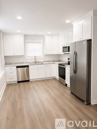 A kitchen with white cabinets and a stainless steel refrigerator.