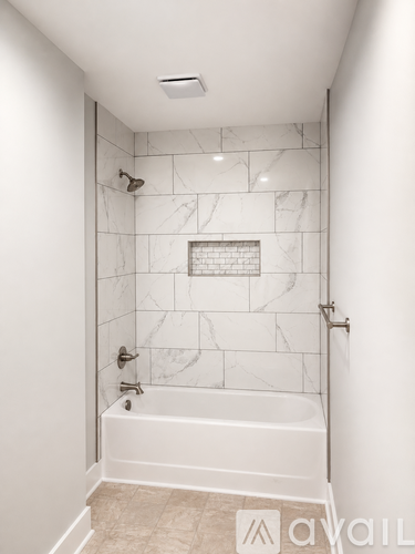 A white bathroom with a marble tile shower.