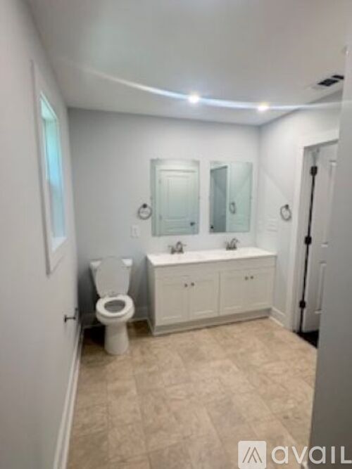 A bathroom with a toilet, sink, and mirror.