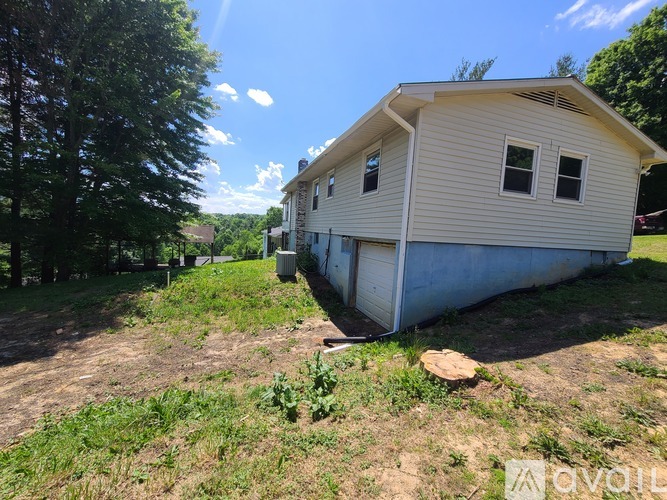 A house with a garage is situated in a grassy area.
