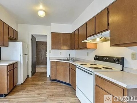 A kitchen with wooden cabinets and white appliances.