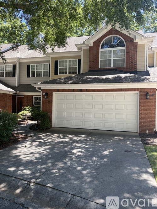 A house with a white garage door in front of it.