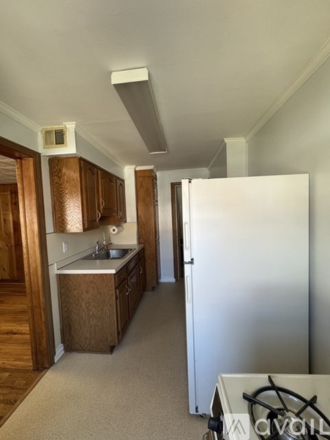 A kitchen with wooden cabinets and a white refrigerator.