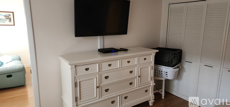 A white TV stand with a black screen TV on top of it.