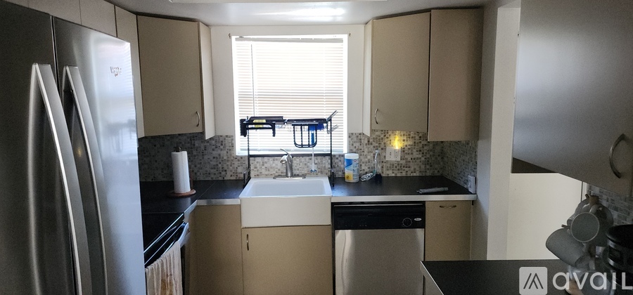 A kitchen with a black counter top and white appliances.