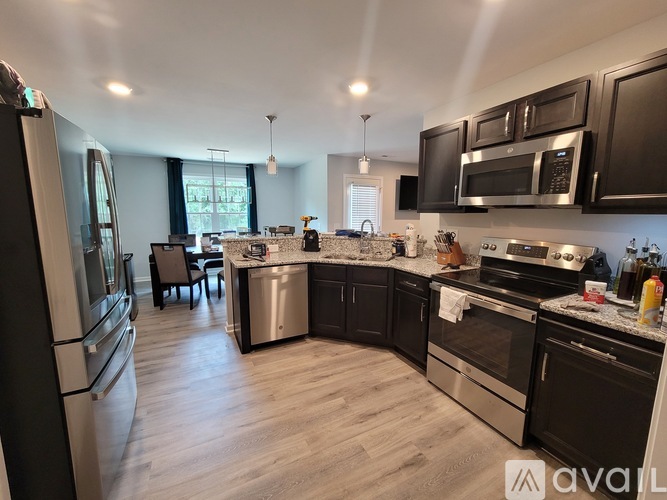 A modern kitchen with dark wood cabinets and stainless steel appliances.