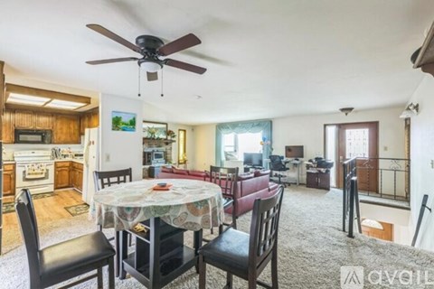 A living room with a dining table set up with chairs.