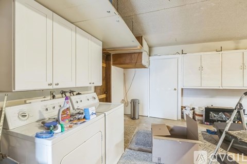A kitchen with white appliances and cabinets is shown.
