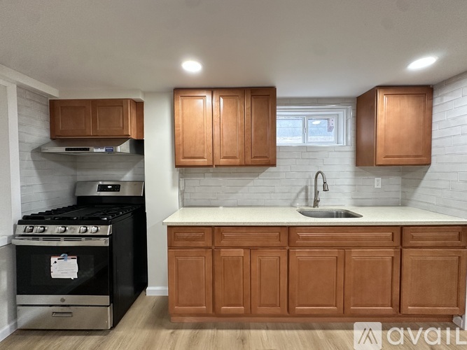 A kitchen with wooden cabinets and a stove top oven.