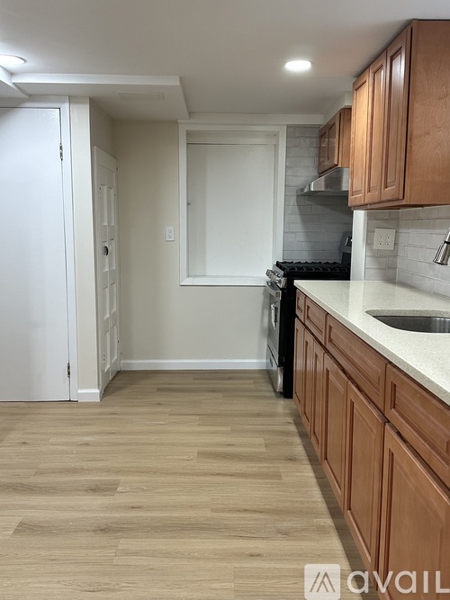 A kitchen with wooden cabinets and a black dishwasher.