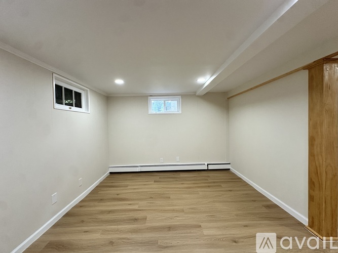 A room with wooden flooring and a window with blinds.