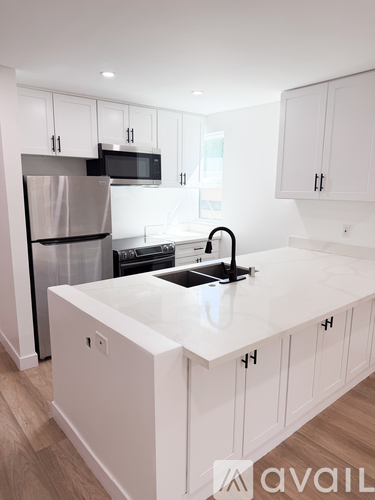 A kitchen with white cabinets and a white countertop.