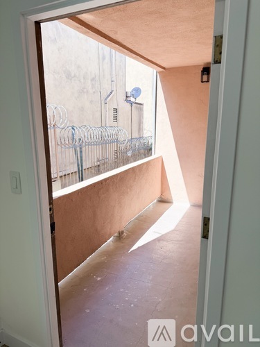 A room with a view of a balcony with a railing.