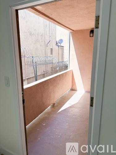 A room with a view of a balcony with a railing.