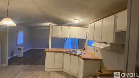 A kitchen with white cabinets and a wooden countertop.