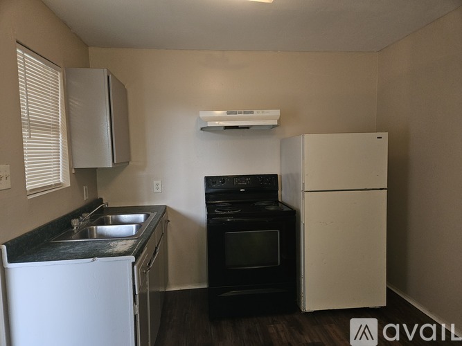 A kitchen with a black oven and white fridge.