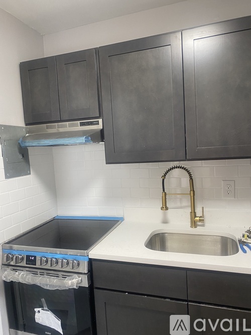 A kitchen with a stove top oven and a sink.