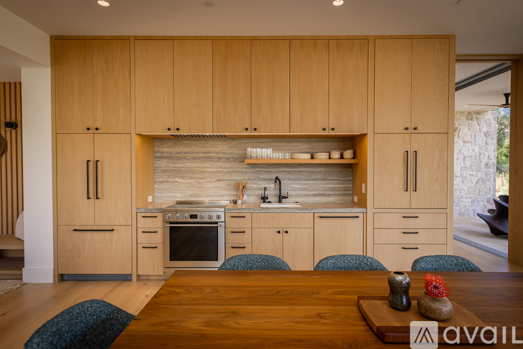 A kitchen with wooden cabinets and a stone backsplash.