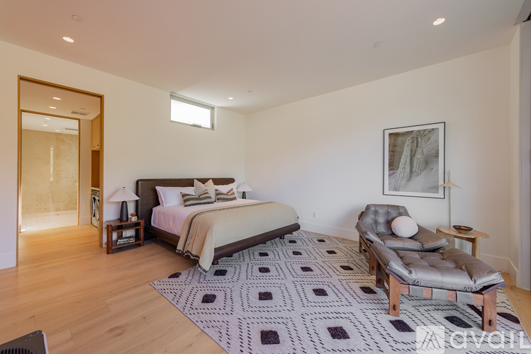 A bedroom with a large bed and a chaise lounge.