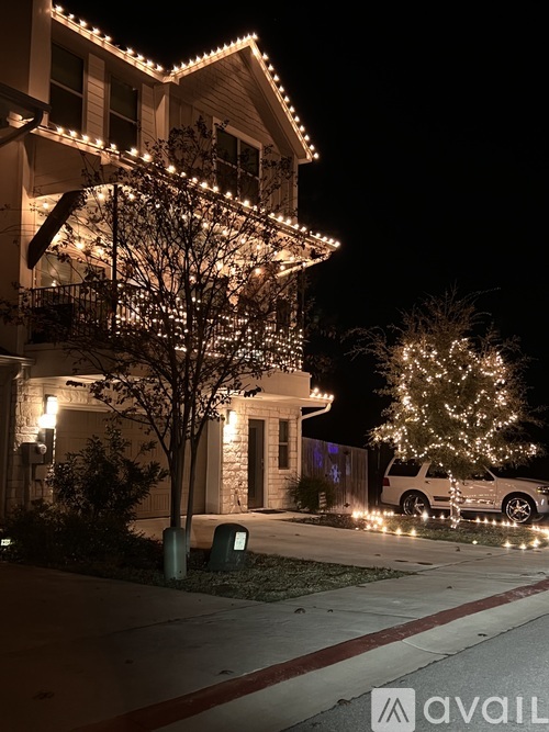 A house with Christmas lights and a tree in front.