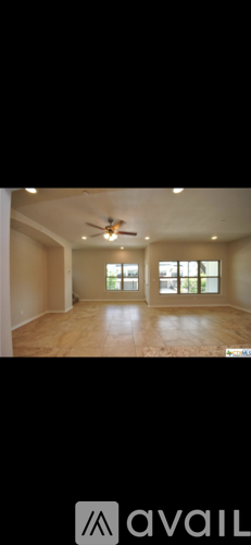A spacious room with a ceiling fan and large windows.