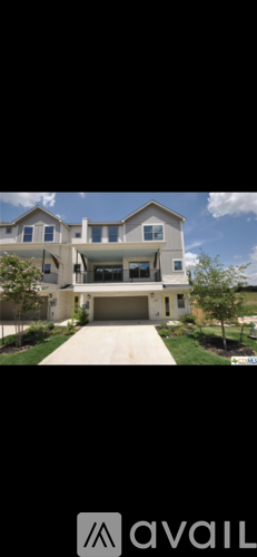 A modern house with a large front yard and a driveway leading to the garage.