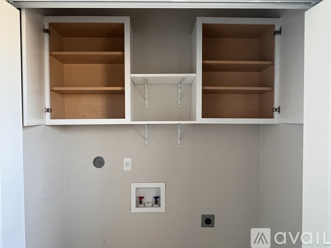 A kitchen cabinet with two shelves and a small drawer is open.