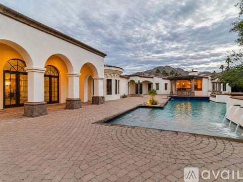 A villa with a pool in the foreground and a mountain in the background.