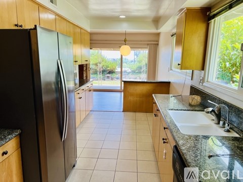 A kitchen with a black refrigerator and a black dishwasher.