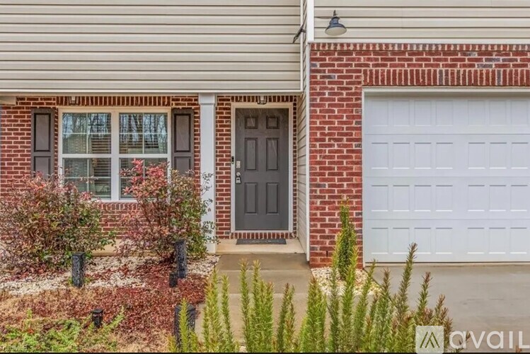 A house with a brown door and a white garage door.
