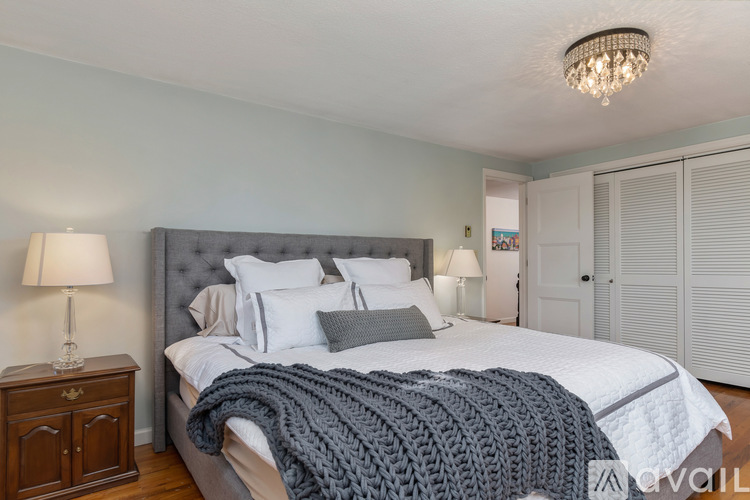A bedroom with a large bed and a chandelier.