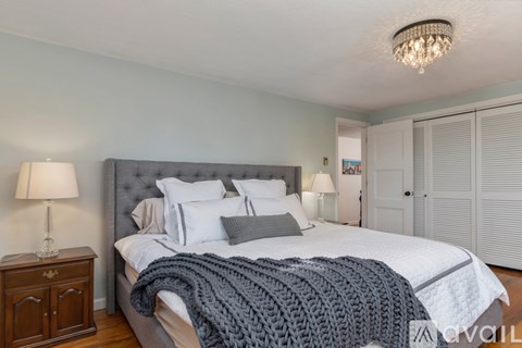 A bedroom with a large bed and a chandelier.
