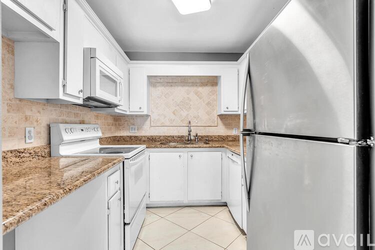 A kitchen with white appliances and a granite countertop.