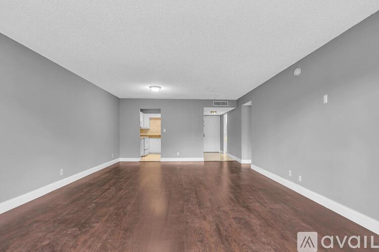 A spacious room with wooden floors and white walls.