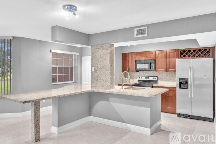A kitchen with a granite countertop and a refrigerator.