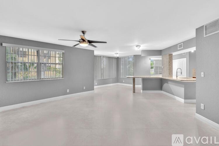 A spacious room with a fan and a table.