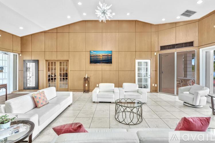 A living room with a white couch, a coffee table, and a painting on the wall.