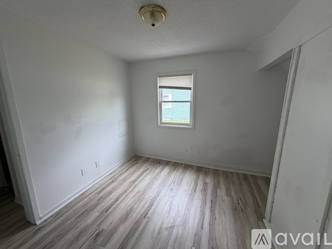 A room with wooden flooring and a window.