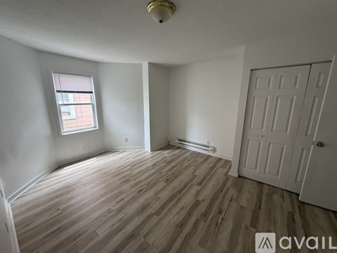 A room with wooden flooring and a white door.