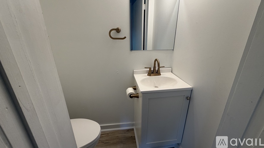 A small white bathroom with a toilet, sink and mirror.