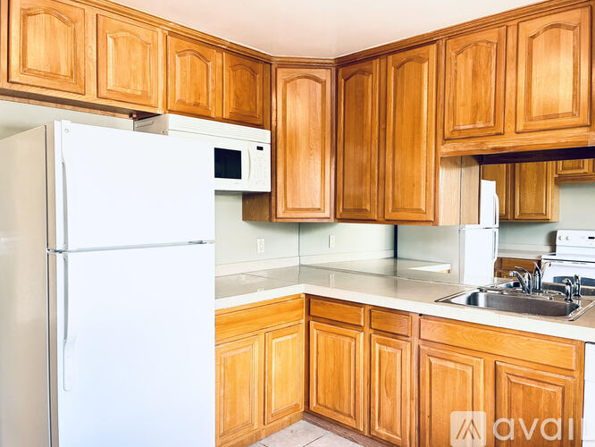 A kitchen with wooden cabinets and a white refrigerator.