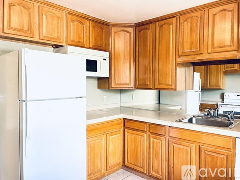 A kitchen with wooden cabinets and a white refrigerator.