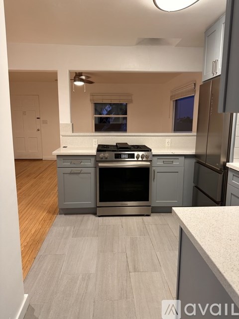 A kitchen with a stove top oven and a refrigerator.