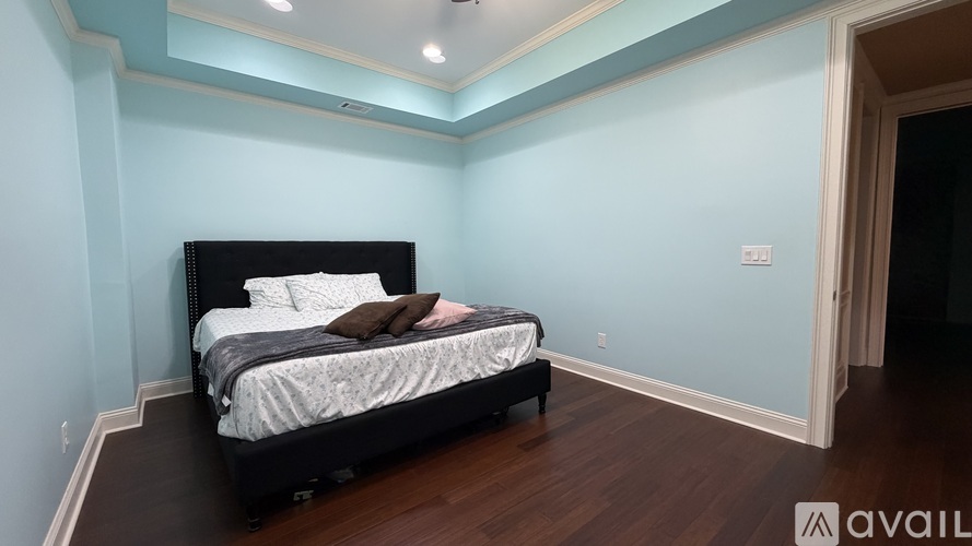 A bedroom with a large bed and wooden floors.