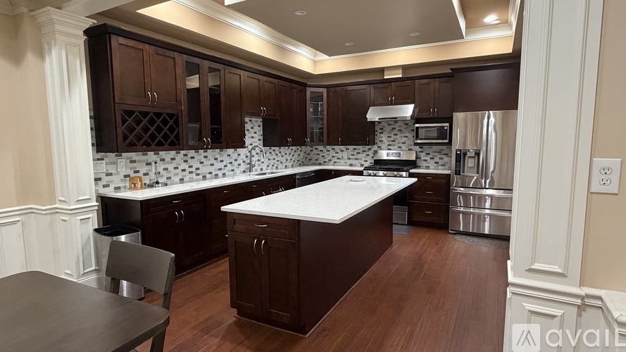 A kitchen with dark wood cabinets and a white countertop.