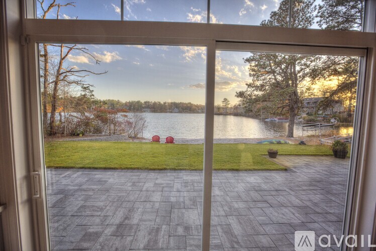 A view from a window looking out to a lake and a grassy area.