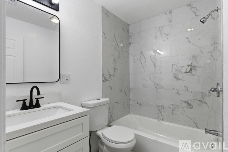 A bathroom with a marble tile wall and a white toilet.