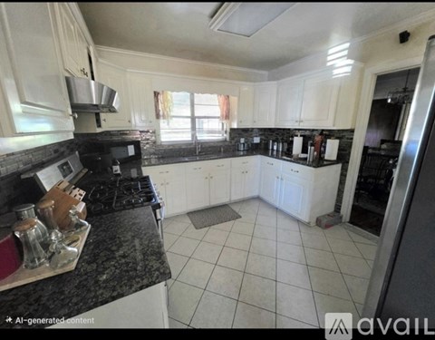 A kitchen with white cabinets and a black stove top.