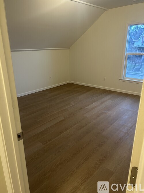 A room with wooden flooring and a window.
